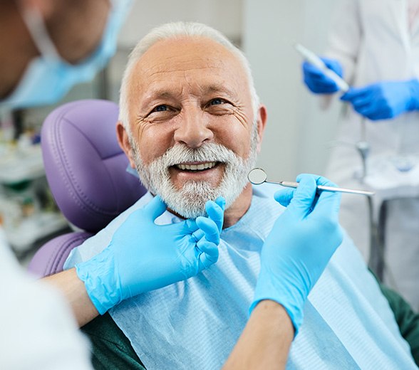 Man with white hair having dental exam