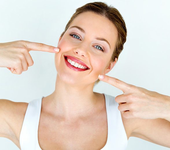 Smiling woman pointing to her teeth