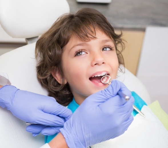 Young patient smiling during children's dentistry checkup and teeth cleaning