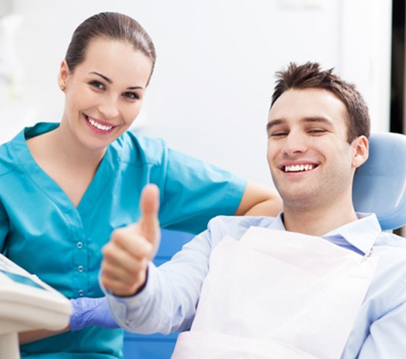 Smiling man in dental chair giving thumbs while visiting a Cigna dentist in Greenville