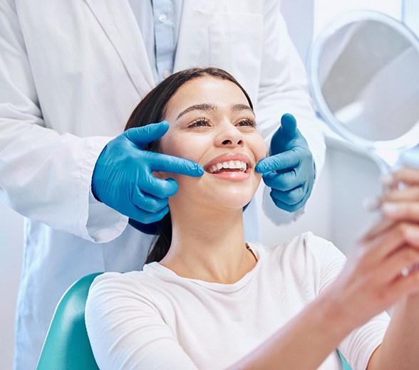 Dental patient looking at her smile in mirror