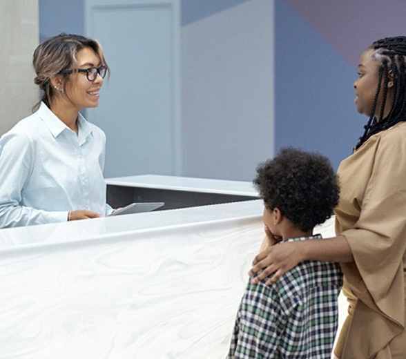 Mother and son talking to dental receptionist about Delta Dental insurance in Greenville