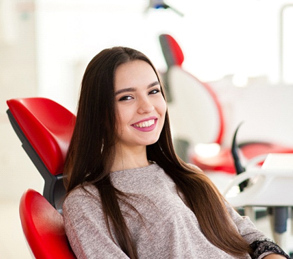 Smiling young woman sitting in dental chair