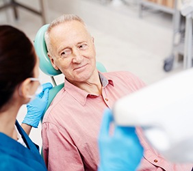 Adult patient looking at dentist assistant in treatment room