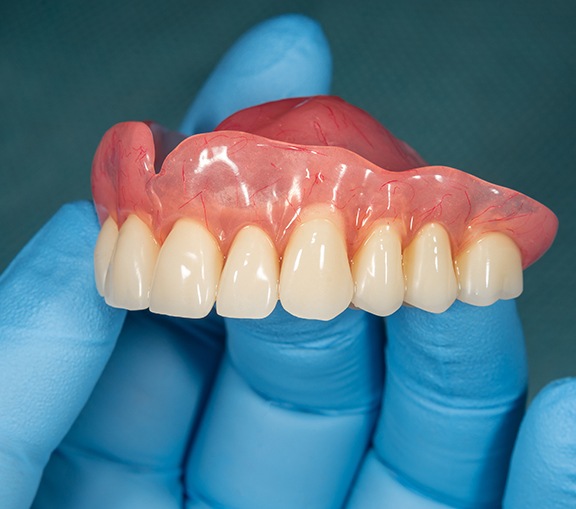 Dentist holding dentures