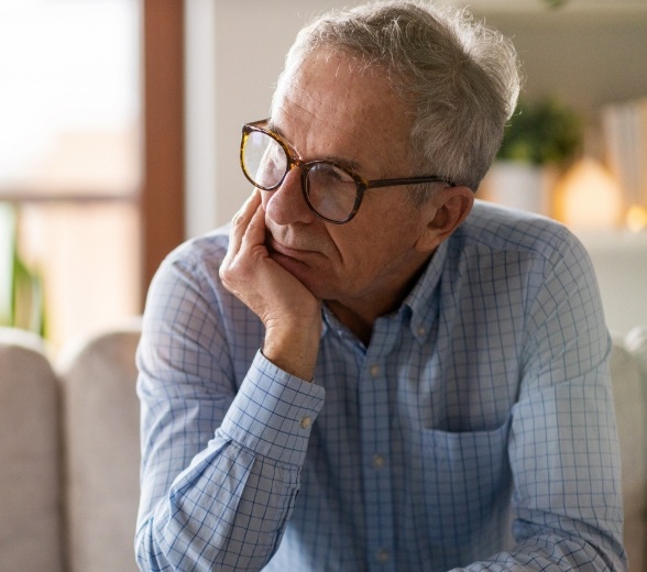 Man with glasses looking contemplative