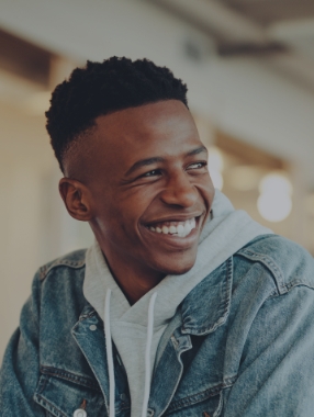 Young man in denim jacket smiling