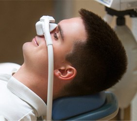 Smiling patient in white shirt breathing in nitrous oxide