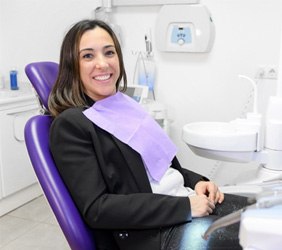 Woman smiling while sitting in dental treatment chair