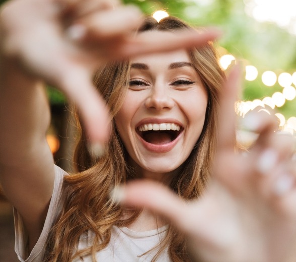 Woman showing off her smile after restorative dentistry treatment