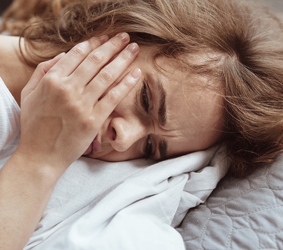 woman toothache in bed for root canal therapy in Greenville  