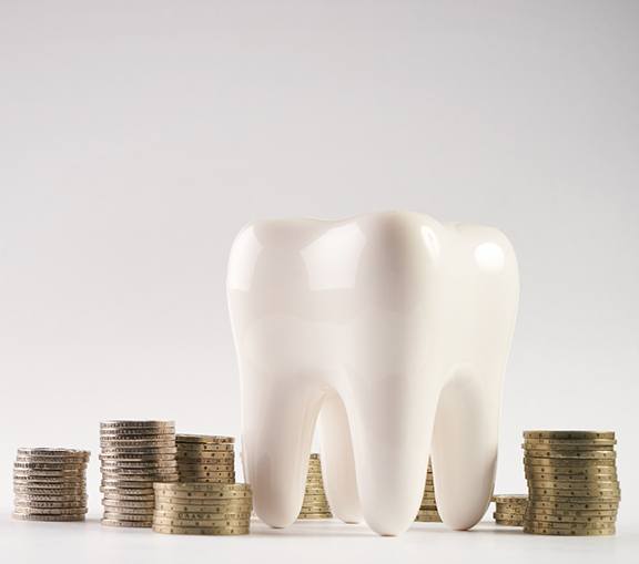 Model of a tooth surrounded by coins