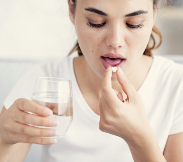 Woman taking pill for oral conscious dental sedation