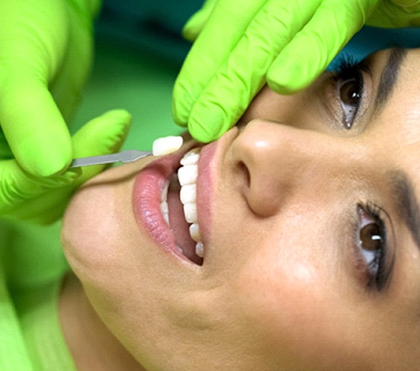 Woman getting veneers in Greenville placed over her teeth