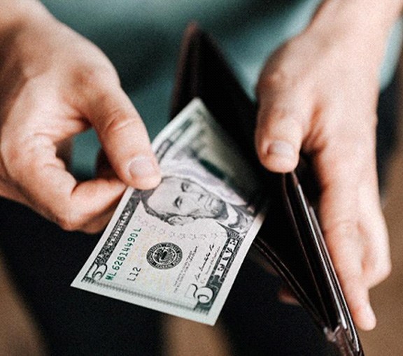 Man looking at cash in wallet