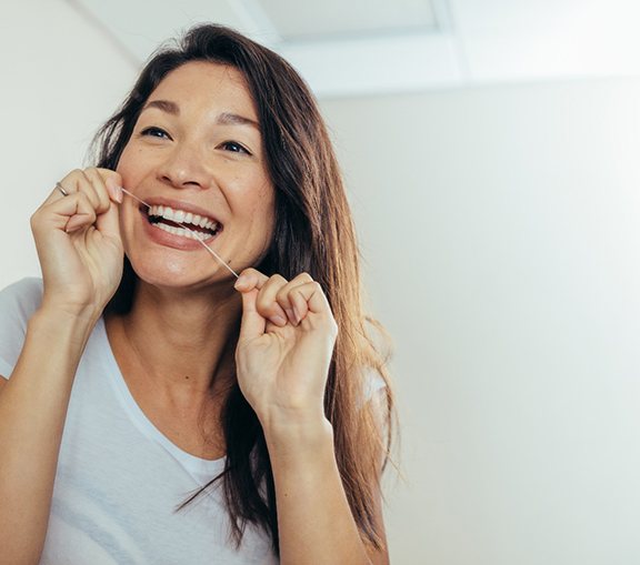 Woman flossing her teeth