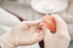 Dentist holding dentures. 