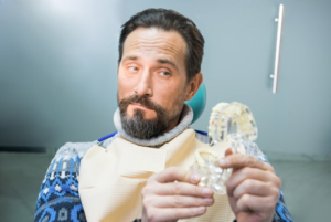 Patient looking at model dentures with a raised eyebrow