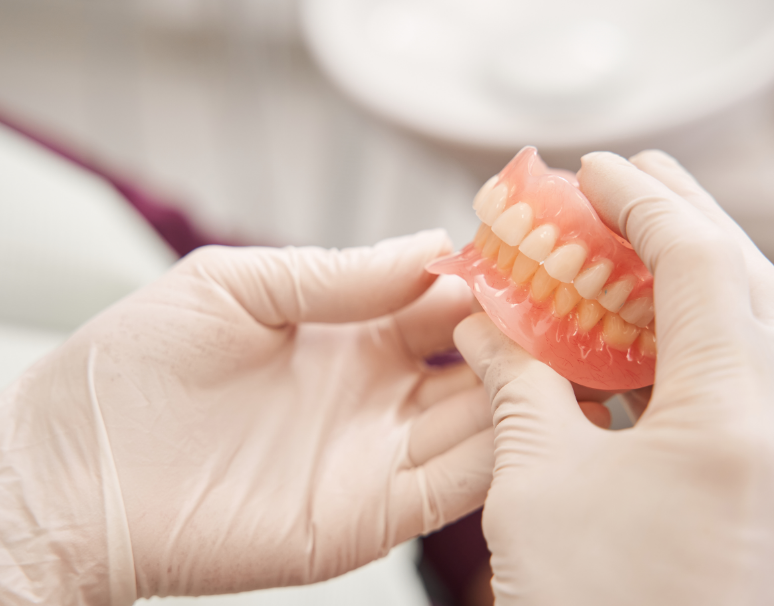 Dentist holding dentures